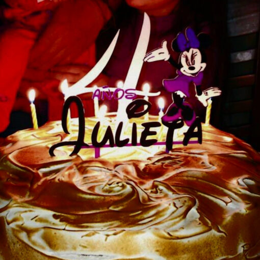 Cake Topper personalizado con un nombre y temática de Minnie puesto en la torta de cumpleaños.