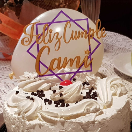 Cake topper en la torta decumpleaños con el mensaje: Feliz cumple Cami y diseño de cuadros.